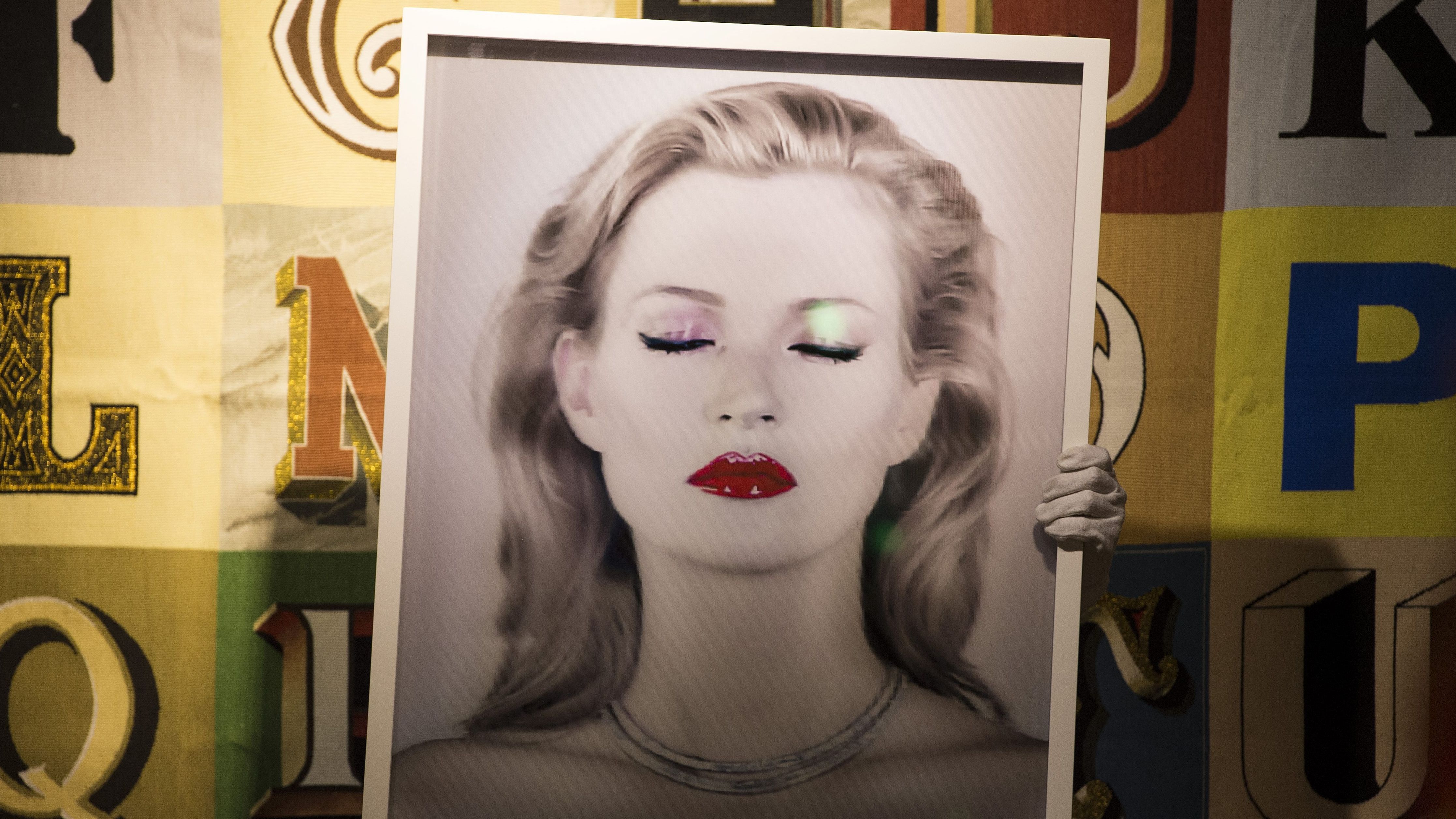 A gallery assistant with 'Kate Moss She's Ligh
