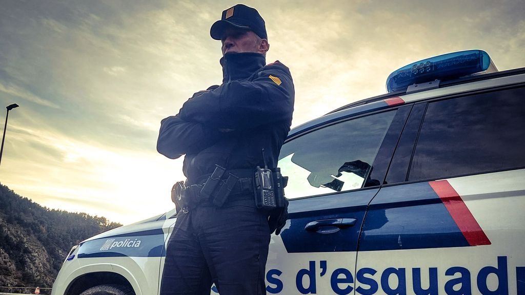 Un agente de la policía catalana junto a un coche
