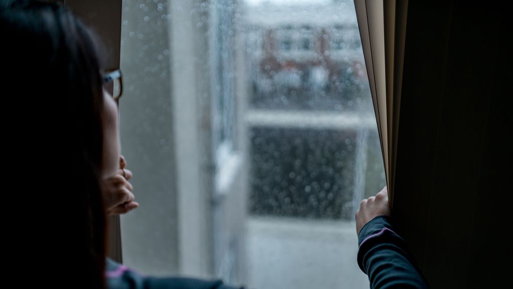 Una mujer se asoma a la ventana para comprobar el tiempo