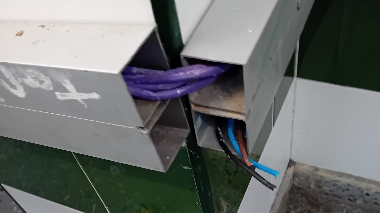 Cables al descubierto, sin protección, en un aula