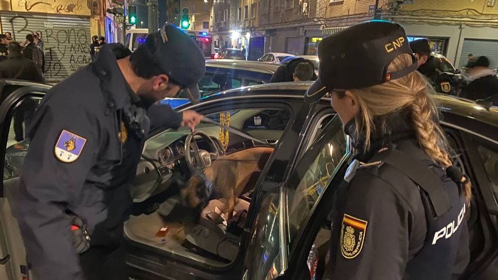 Los agentes controlan con un perro un vehículo en el barrio