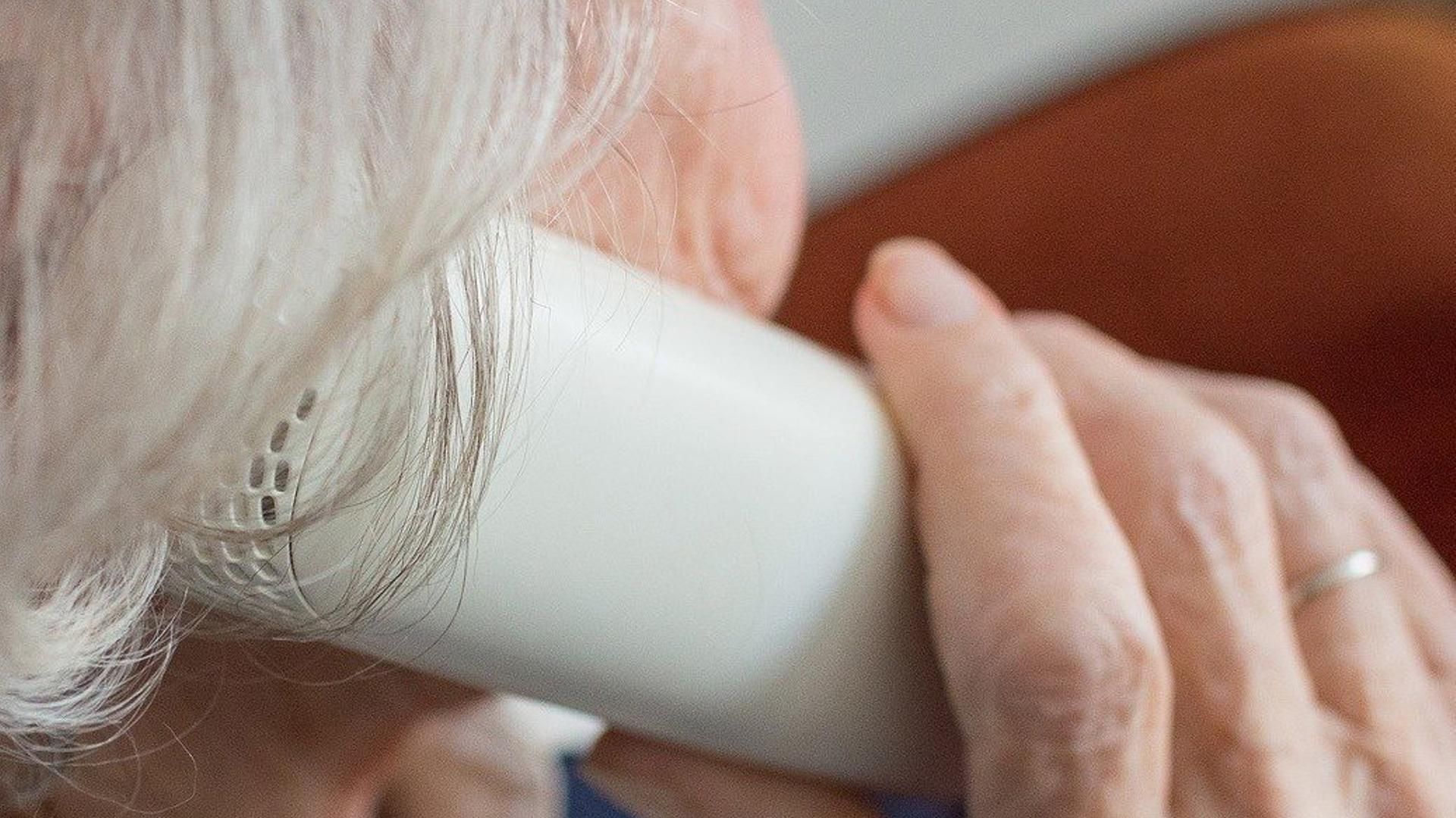 Archivo - Persona mayor al teléfono