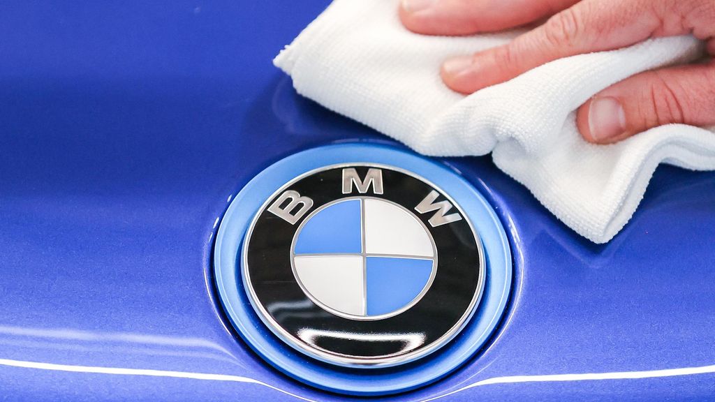 Archivo - FILED - 11 June 2020, Saxony, Leipzig: A BMW employee polishes the logo of a BMW i8 with a cloth. German carmarkers BMW and Mercedes-Benz are selling their joint car-sharing subsidiary Share Now to multinational automotive corporation Stellantis