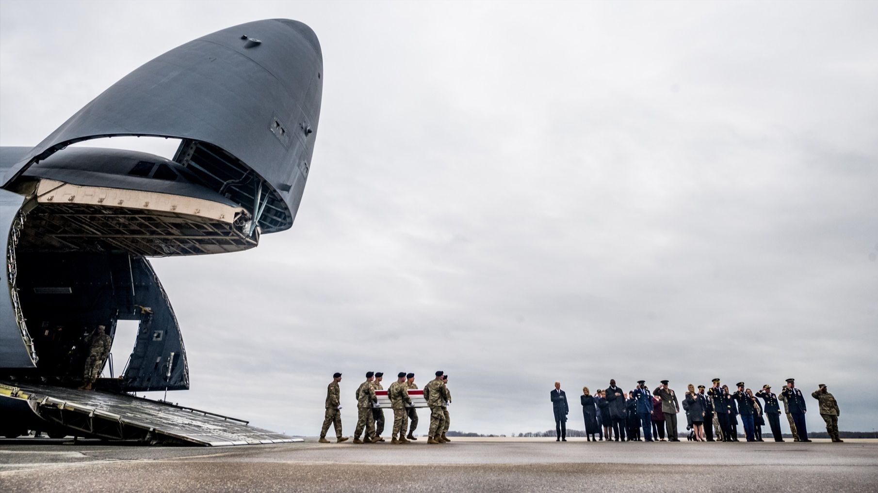 Joe Biden observa cómo un equipo del ejército lleva el féretro de uno de los militares muertos en Jordania