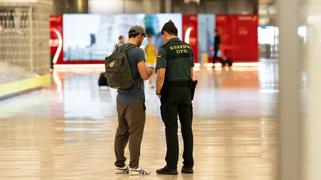 Un agente de la Guardia Civil comprueba la documentación de un pasajero en la T4 del aeropuerto Adolfo Suárez-Madrid Barajas
