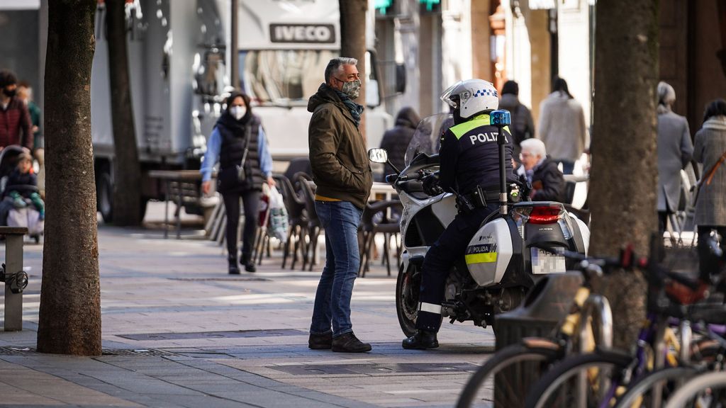 Un agente de Vitoria sobre su moto charla con un ciudadano