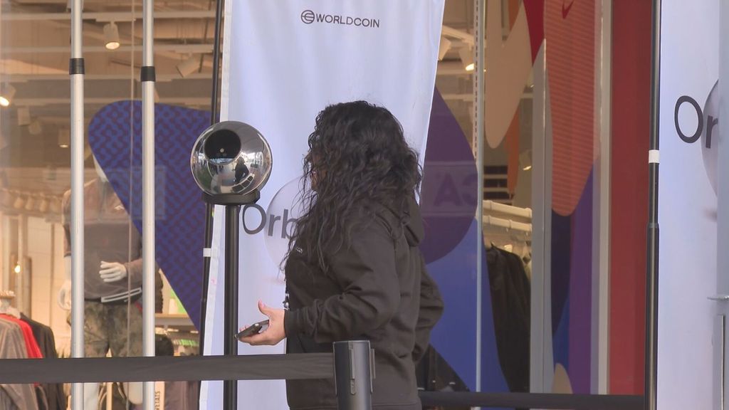 Una mujer se prepara para escanear su iris ante un ORB de Worldcoin en Barcelona