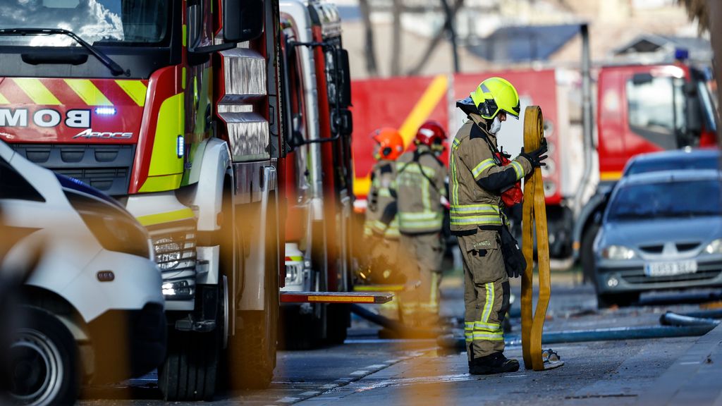 Varios bomberos recogen el material usado en la extinción del incendio en el edificio del barrio de Campanar de Valencia
