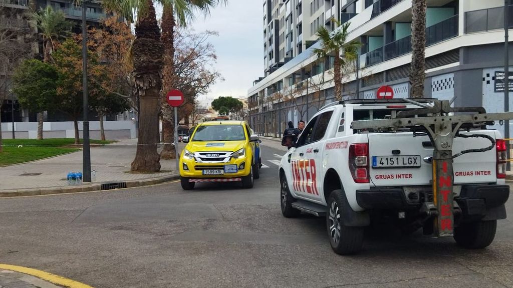 Grúas esperan su turno para acceder al garaje del edificio a recuperar los vehículos de los afectados