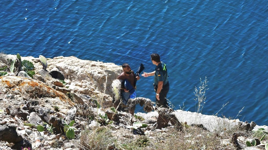 Un agente de la Guardia Civil con uno de los migrantes sirios que ha llegado a nado a las costas de Ceuta, en la barriada del Sarchal.