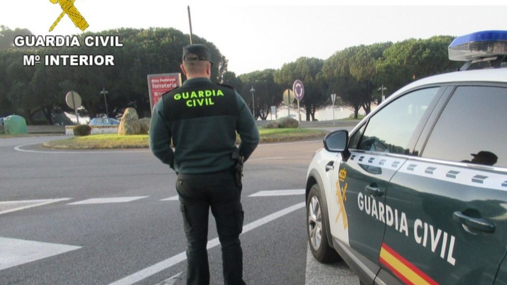 Agente de la Guardia Civil junto a su vehículo