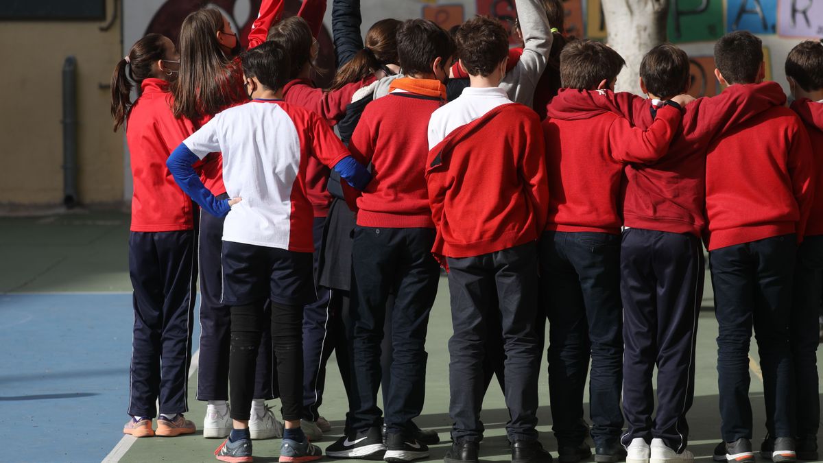 Un grupo de niños y niñas jugando en el patio de un colegio