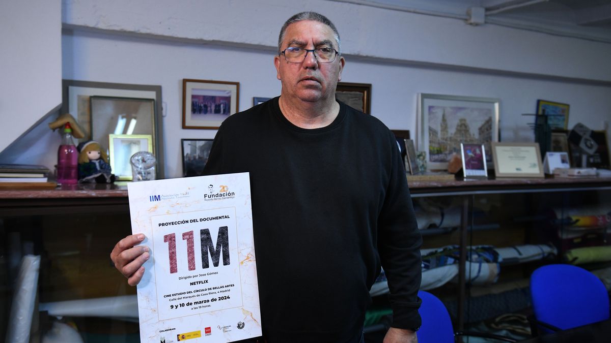 Francisco Alameda, una víctima que pertenece a la asociación, posa con un cartel del aniversario del 11-M