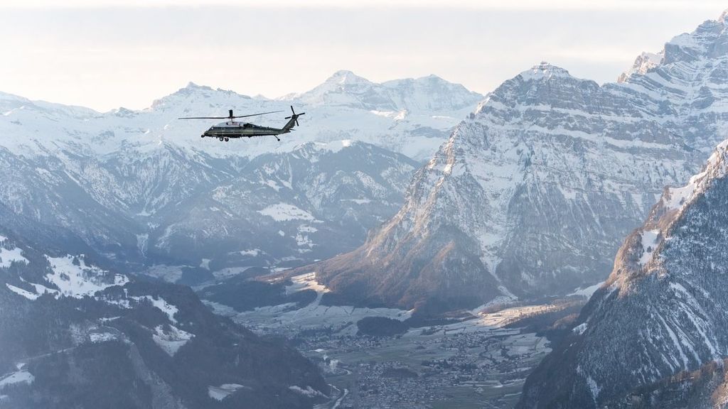 Un helicóptero sobrevuela los Alpes suizos