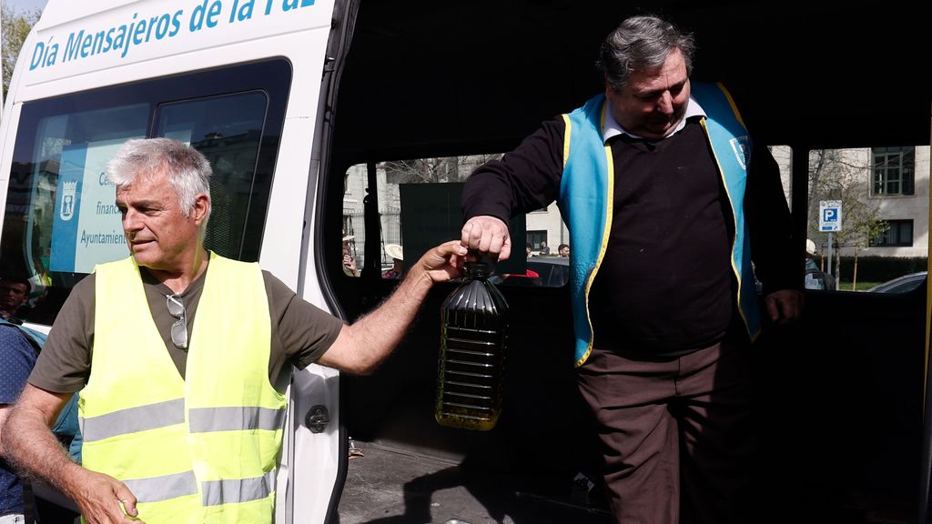 Luis Cortés (i), coordinador general de Unión de Uniones de Agricultores y Ganaderos, hace entrega de una donación de 125 litros de aceite de oliva a la ONG Mensajeros de la Paz