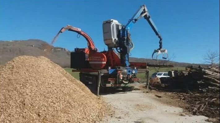 Una empresa corta la leña y la lleva al pueblo donde una máquina la tritura