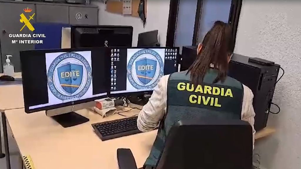 Agente de la Guardia Civil trabajando frente a dos ordenadores