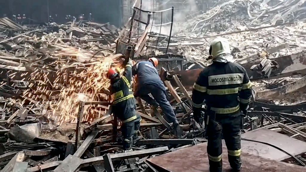 Trabajadores retiran los escombros y extinguen el fuego de la sala de conciertos