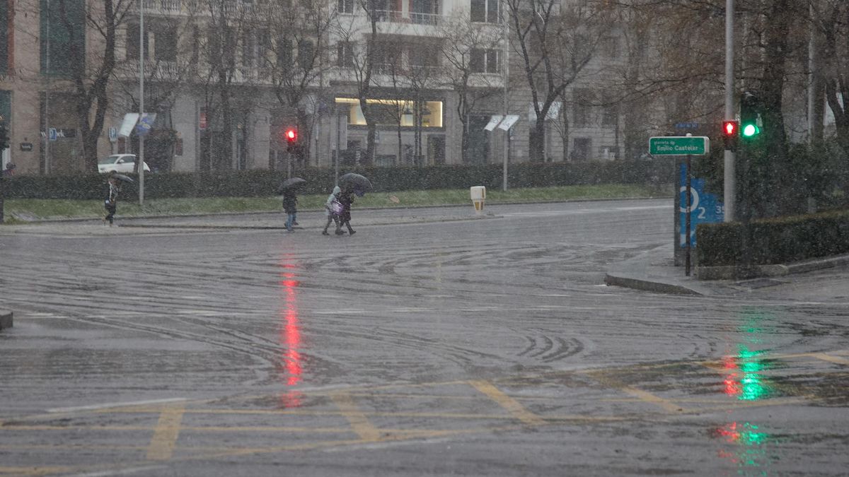 Varias personas cruzan una calle durante la tormenta, en el centro de Madrid, a 2 de marzo de 2024, en Madrid (España). La Agencia Estatal de Meteorología (AEMET) ha activado el aviso amarillo en la Comunidad de Madrid por fuertes rachas de viento de hast