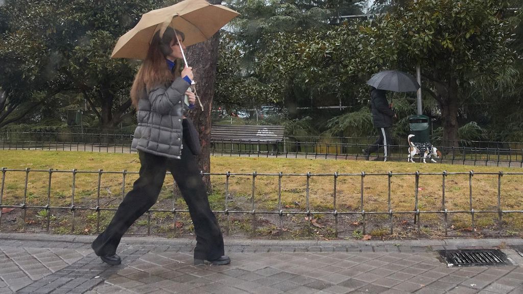 Una mujer se protege de la lluvia con un paraguas durante la borrasca ‘Karlotta’, en una foto de archivo.