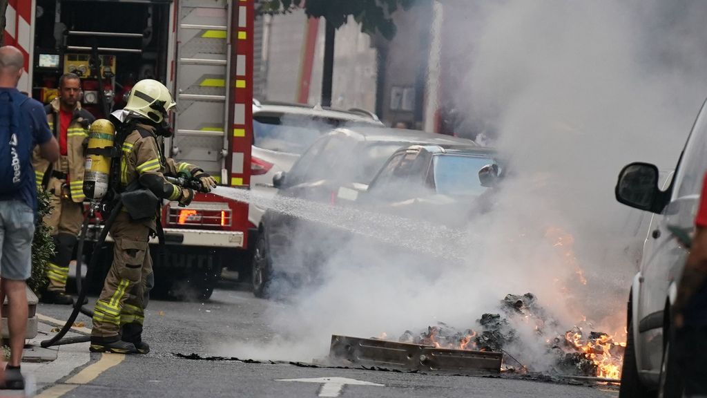 Un bombero apaga un contenedor quemado en Bizkaia.