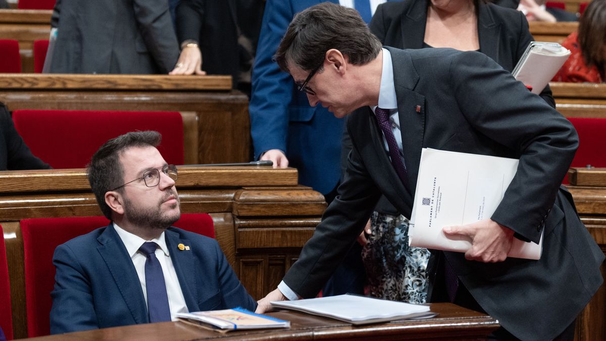 El presidente de la Generalitat de Catalunya, Pere Aragonés (i) y el líder del PSC, Salvador Illa (d), conversan durante una sesión de control al Govern, en el Parlament