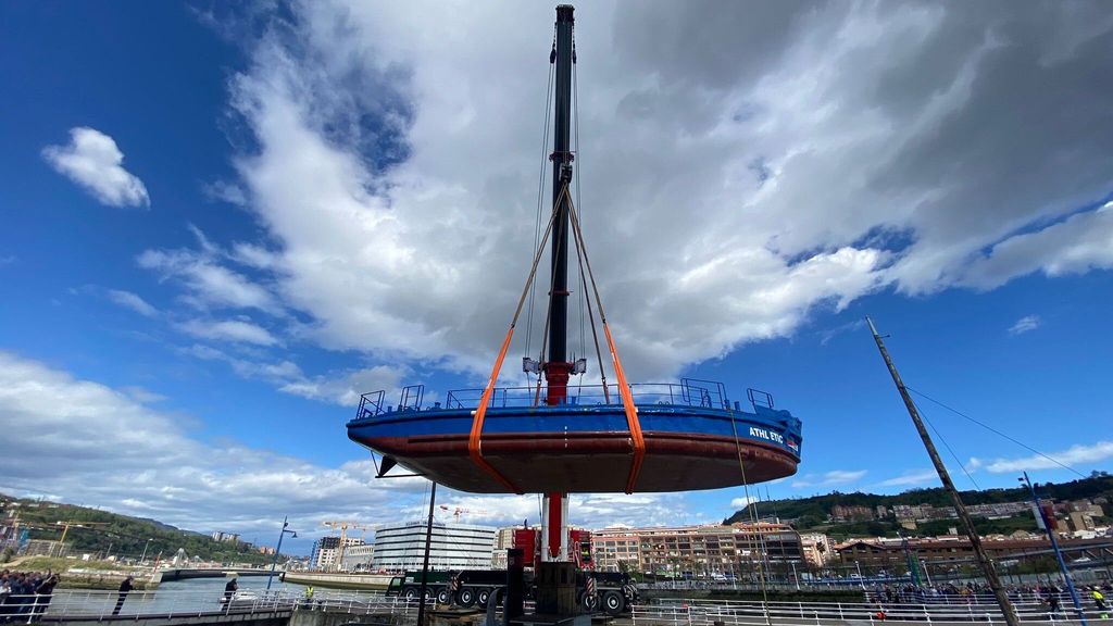 Una grúa ha levantado la gabarra del dique de Itsasmuseum para colocarla en la ría