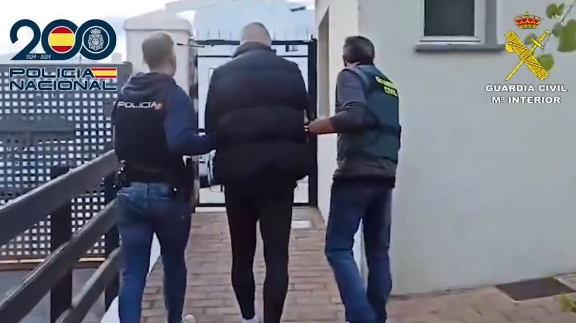 Un detenido con agentes custodiándolo