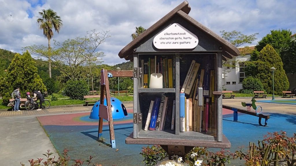 'El compartir nos enriquece, coge y deja a tu antojo', se puede leer en la pequeña biblioteca instalada junto al banco
