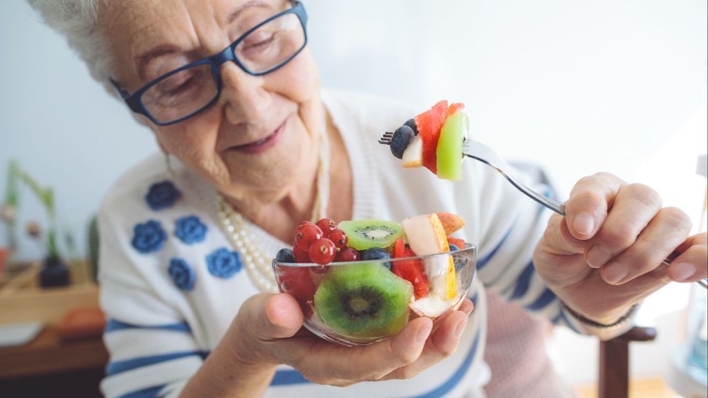 Señora comiendo kiwi.