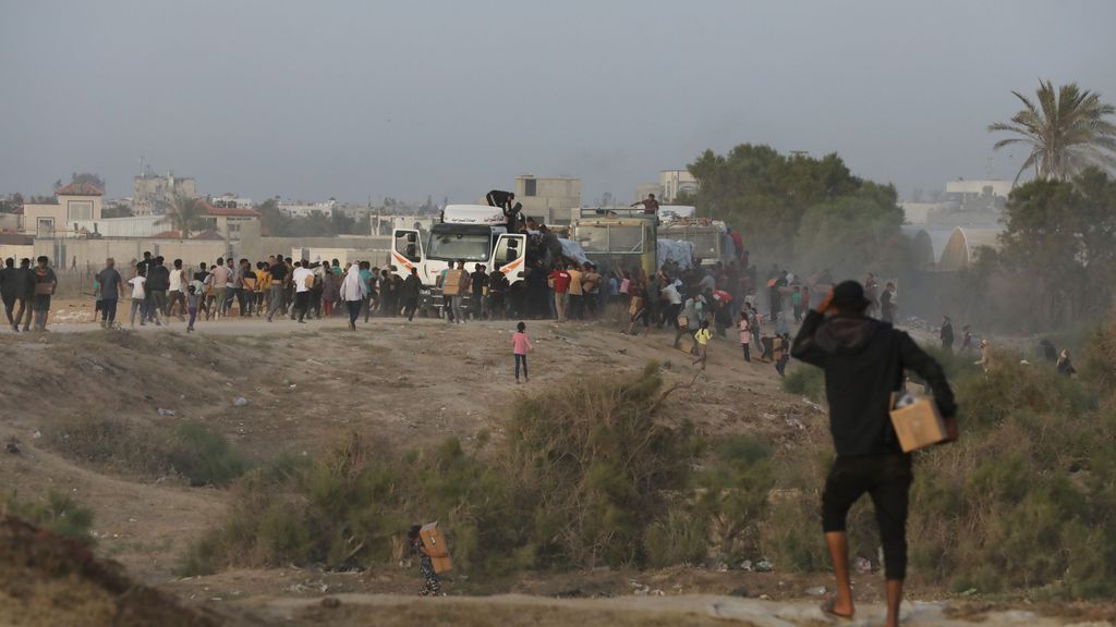 Palestinos recogen cajas con ayuda humanitaria tras interceptar camiones que trasladaban la asistencia descargada a través del muelle temporal construido por Estados Unidos en la costa de la Franja de Gaza (archivo)