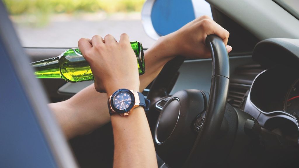 Una mujer conduce mientras toma una bebida