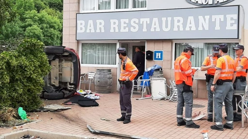 Agentes de la Policía Foral en el lugar donde un turismo ha chocado contra la terraza de un bar.