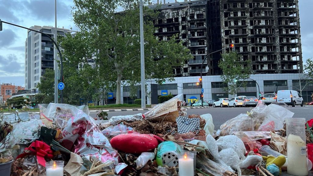 Flores y velas ante los edificios incendiados de Campanar