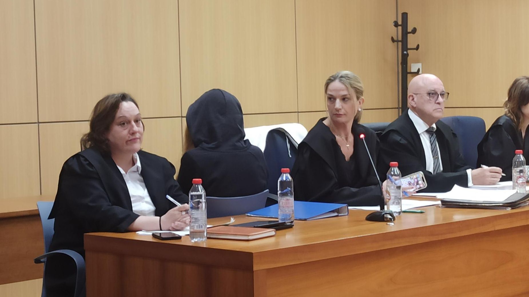 La acusada de espaldas con una capucha en la sala La acusada de espaldas con una capucha en la sala