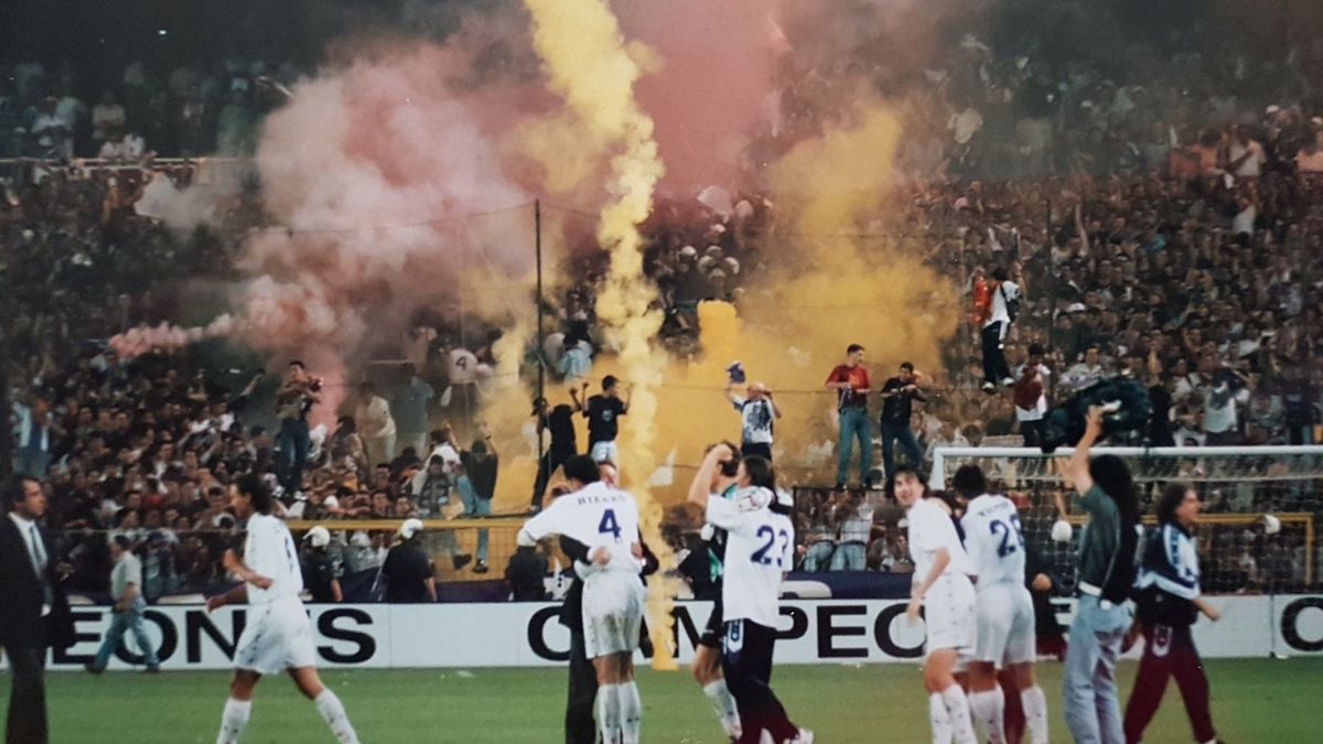 El fondo sur del Santiago Bernabéu, lleno de botes de humo, con los jugadores del Real Madrid sobre el césped