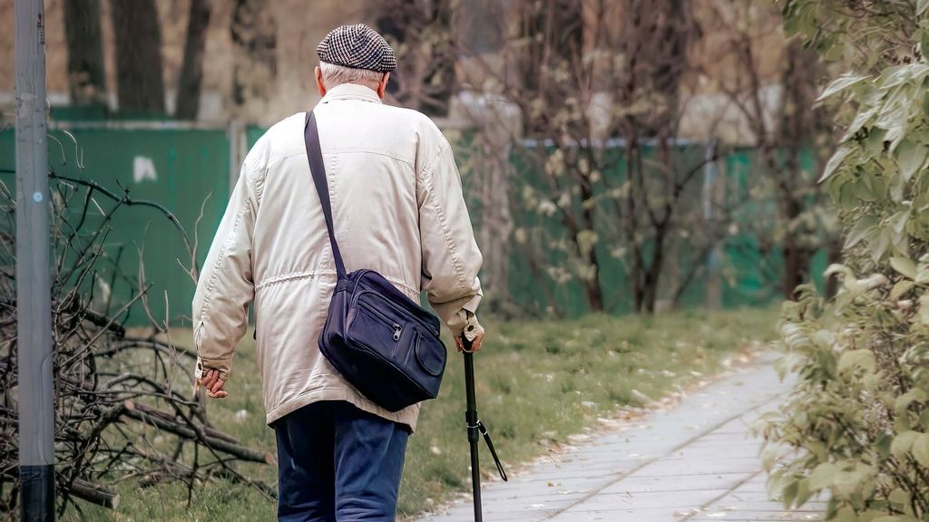 Anciano caminando sólo con su bastón