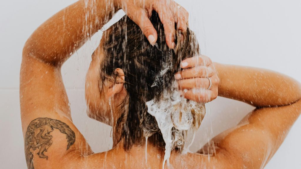 Una mujer lavándose el pelo