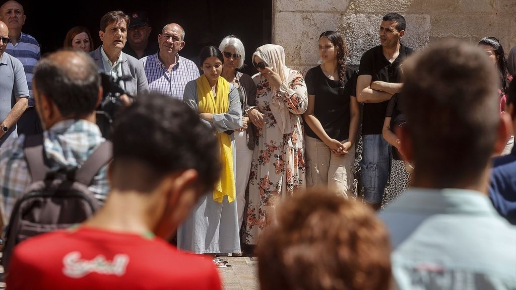 Varias personas se abrazan durante un minuto de silencio en Alzira por el fallecimiento de un niño de once años ahogado en el río Júcar