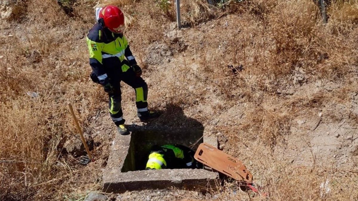 Bomberos rescatando a un motorista fallecido de una arqueta en Málaga