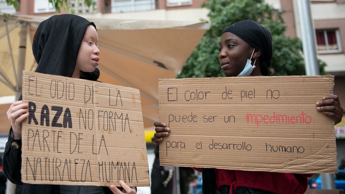 Dos personas participan en una concentración contra el racismo.