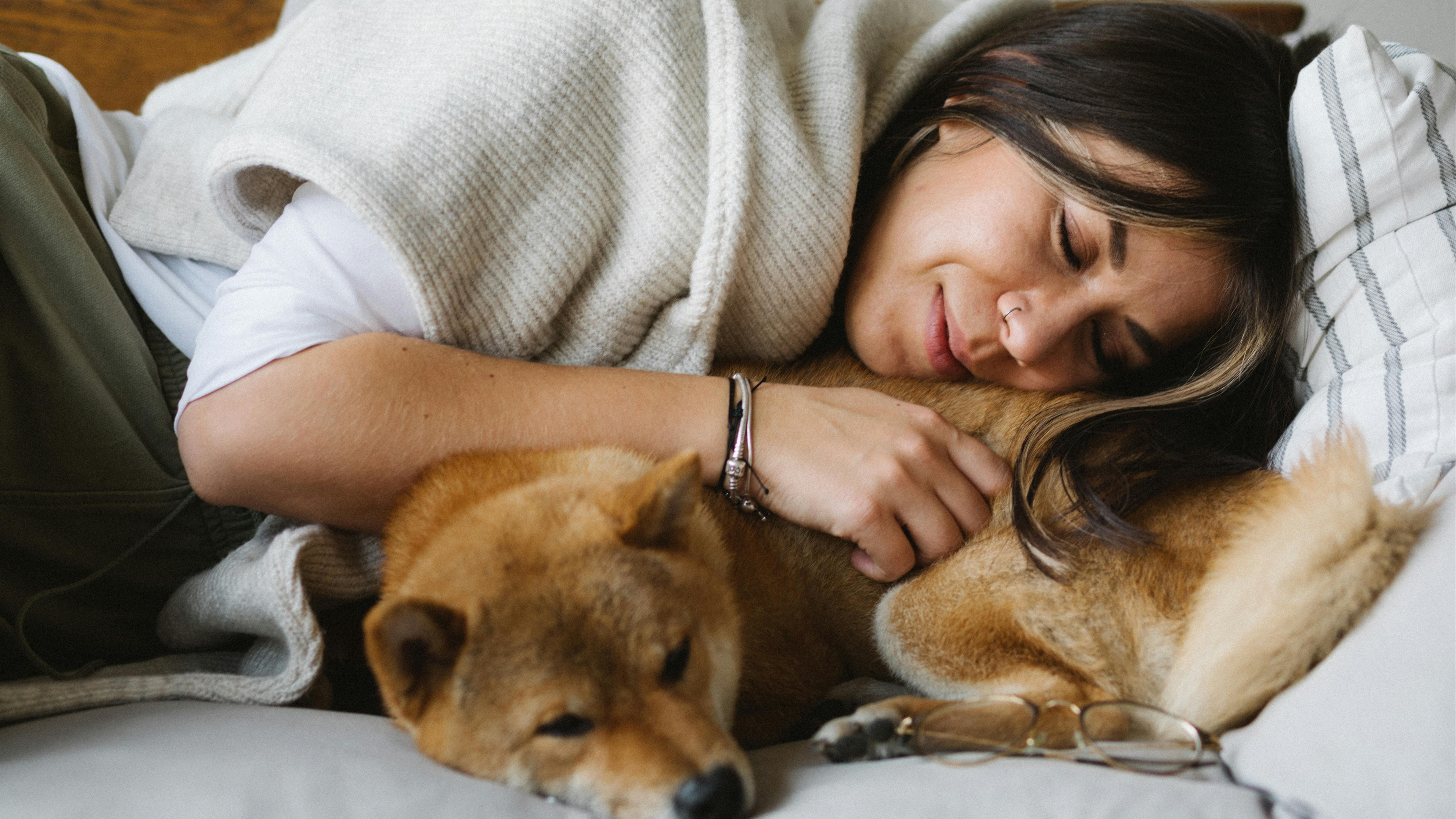 Una mujer durmiendo la siesta con su perrito