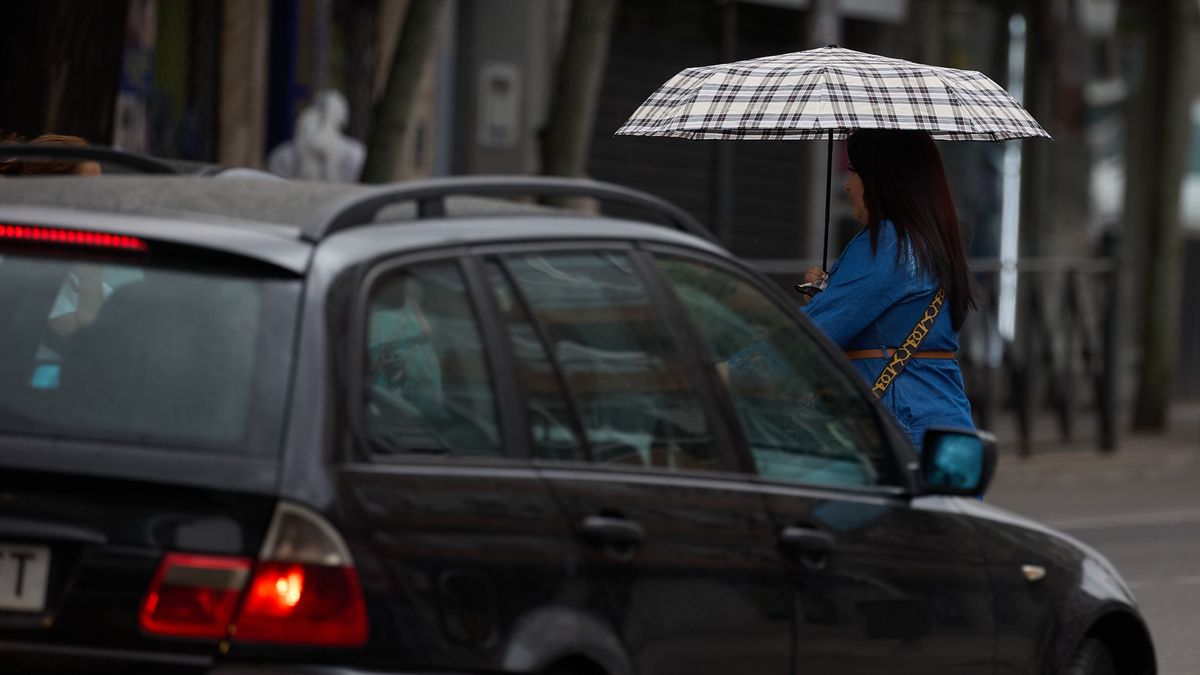 Una mujer se protege de la lluvia con un paraguas en Madrid