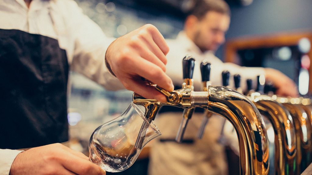 Dos camareros sirven cerveza en un bar