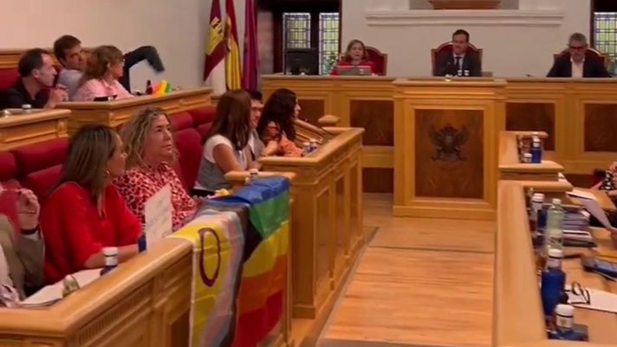 Los concejales socialistas de Toledo mantienen una bandera LGTBI en sus mesas antes de ser retirada por un Policía Local