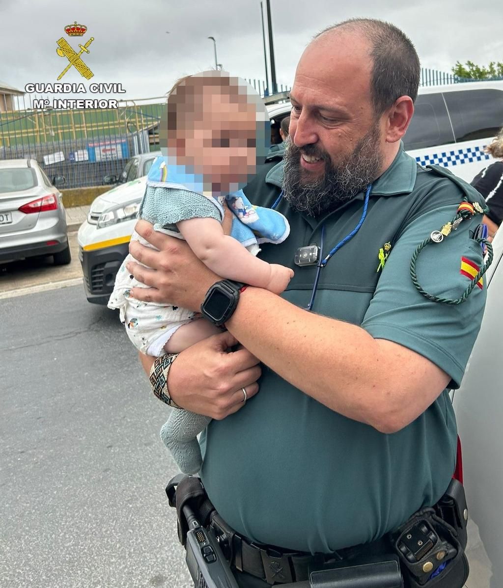 Agente de la Guardia Civil de Lepe (Huelva) con el bebé rescatado en brazos.
