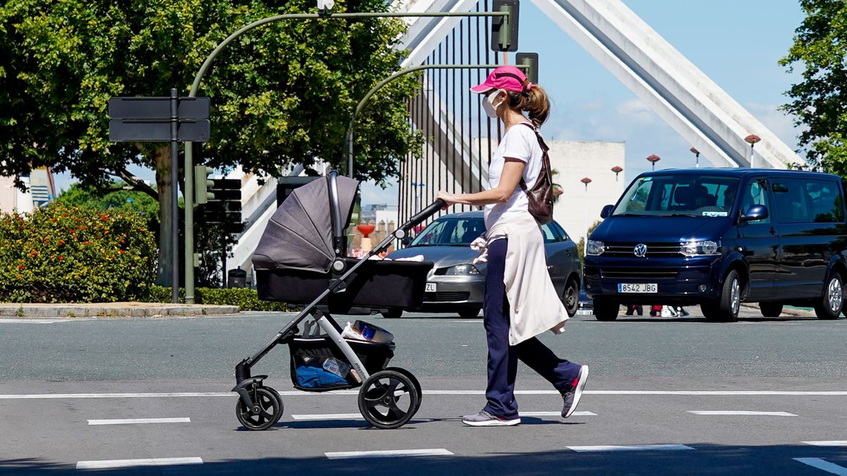 Una madre pasea con su hijo en un carrito