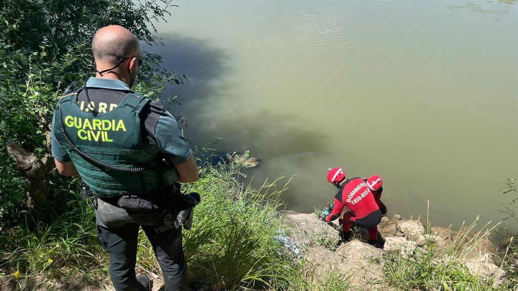 Un agente de la Guardia Civil y dos bomberos junto al río Ebro, donde ha aparecido el cadáver