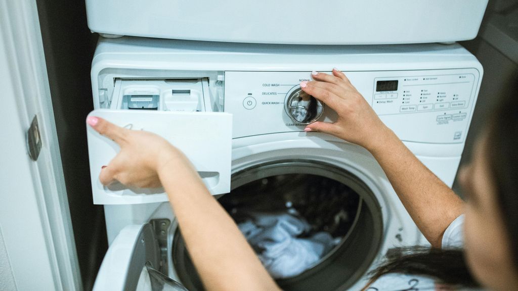 Una mujer poniendo la lavadora