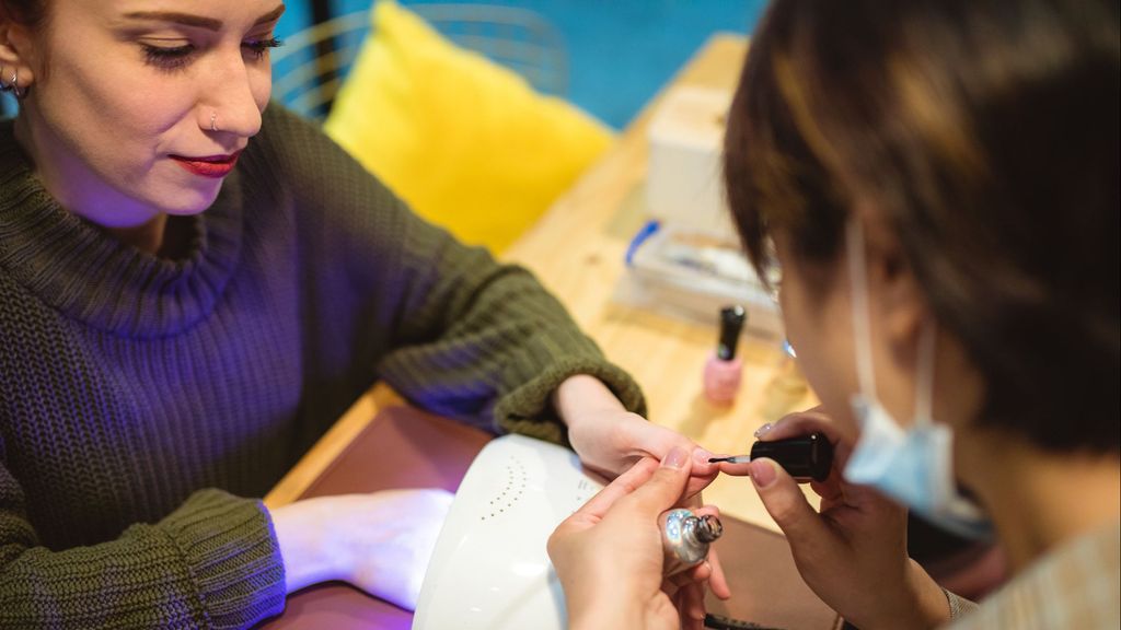 Una chica haciéndose la manicura semipermanente